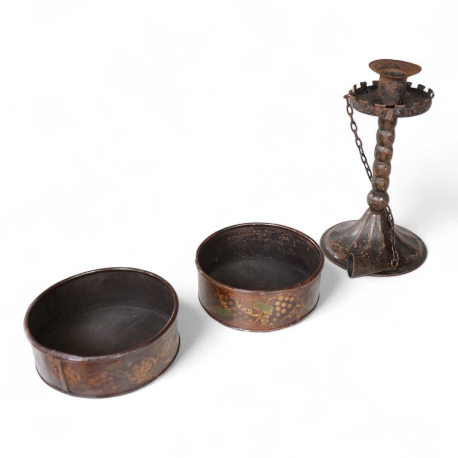 A pair of 19th century toleware wine coasters and an Arts & Crafts iron candlestick with attached snuffer, 21cm high